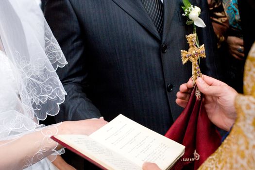 cross and Bible in the hands of the priest