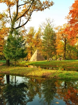 Northern pyramid near water in autumn park