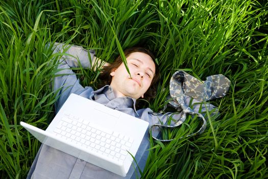 businessman rest on the grass with laptop