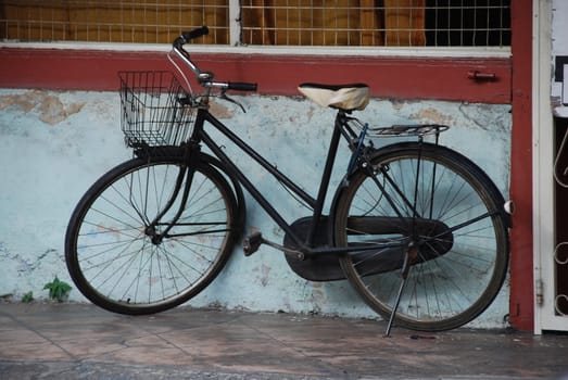Old bicycle alongside a building