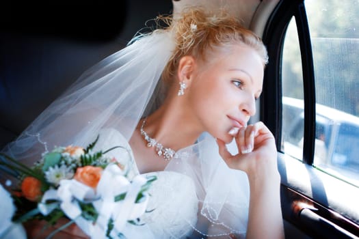 The happy bride in the car