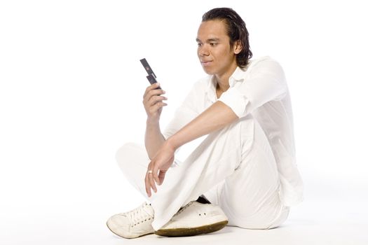 Studio portrait of a muscular Asian sexy looking boy looking at his mobile