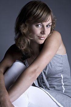 Studio portrait of a teenage model sitting on the floor