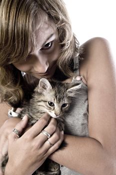 Studio portrait of a teenage model posing with a kitten