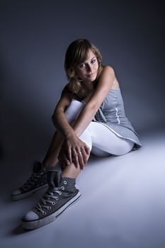 Studio portrait of a teenage model showing of her sneakers. no copyrighted signs