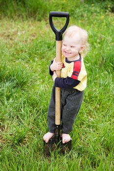 small girl on the shovel in the garden