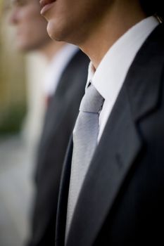 close view of two businessmen standing side to side in profile view