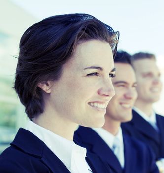 head and shoulders of three business people looking in same direction smiling