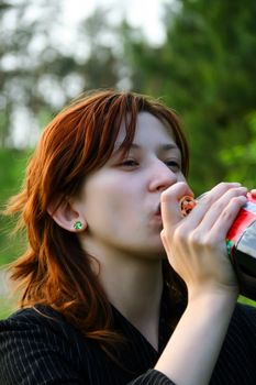 Young woman drink Coca-Cola with pleasure