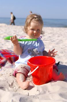 baby girl on the beach and blue sky