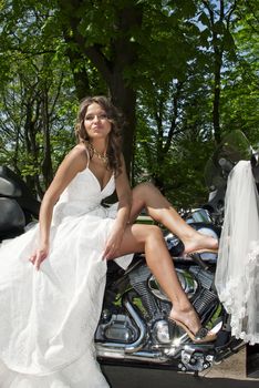 beautiful young bride sitting on a motorcycle