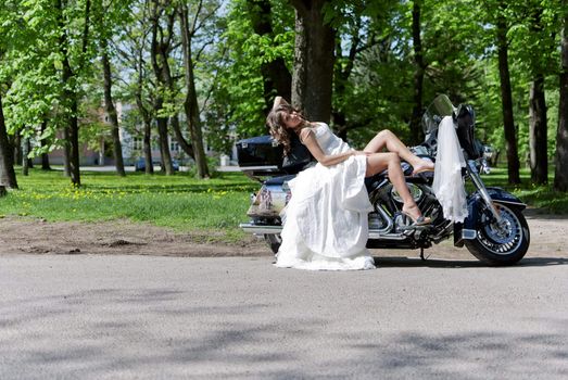 beautiful young bride sitting on a motorcycle