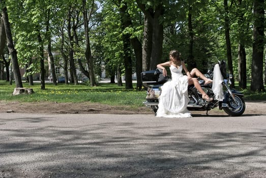 beautiful young bride sitting on a motorcycle
