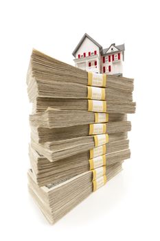 Small House on Stacks of Hundred Dollar Bills Isolated on a White Background.