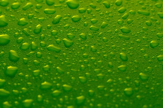 Green water drops background with yellow reflections.