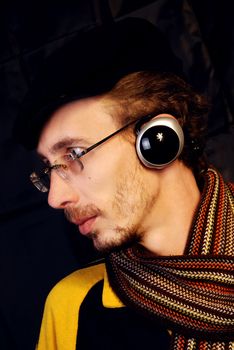The pretty young and serious man listening to music