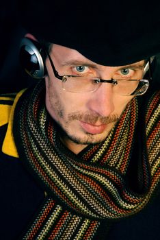 The pretty young and serious man listening to music