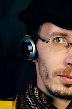 The pretty young and serious man listening to music