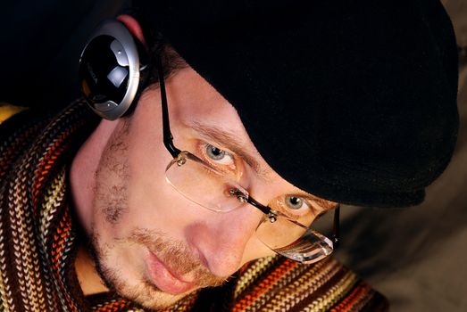 The pretty young and serious man listening to music