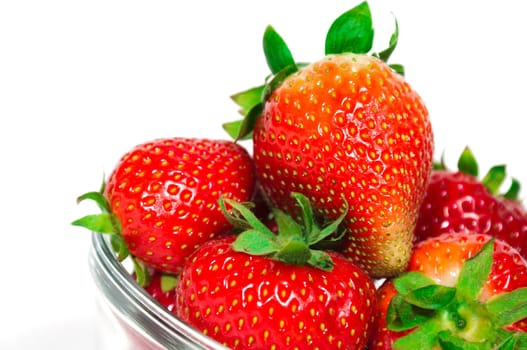 Fresh organic strawberries in a glass bowl, isolated