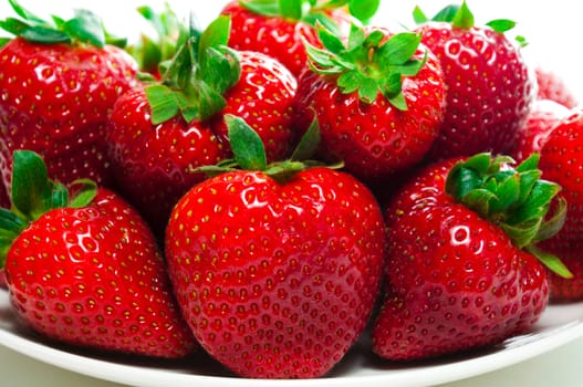 Strawberries on a plate and on the white background