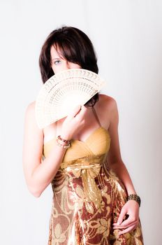 sexy image of beautiful young brunette model holding a white with Chinese hand fan in front of her face