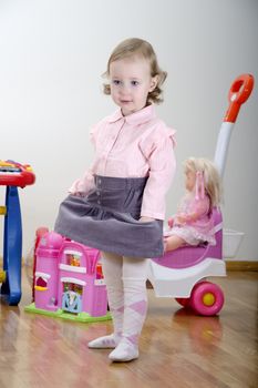 little girl standing in a room with toys