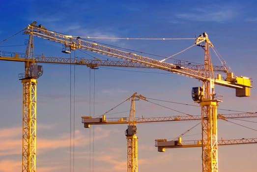 tall cranes on blue sky background