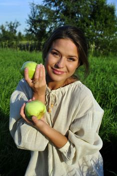 girl in a linen shirt, holding apples