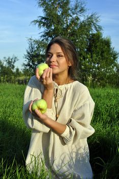 girl in a linen shirt, holding apples