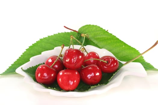 fresh red cherries in a bowl on white background