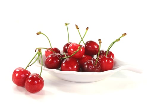 fresh red cherries in a bowl on white background