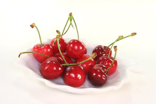 fresh red cherries in a bowl on white background