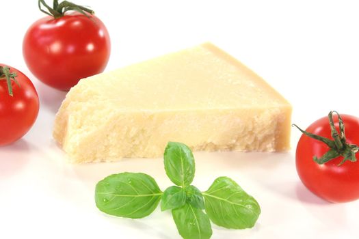 a piece of Parmesan cheese with tomato and basil on a white background