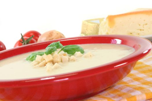 Cheese cream soup with tomato, Croutons and basil on a white background