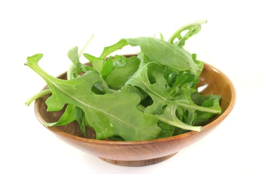 a bowl of rocket leaves on a white background