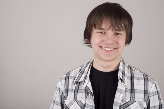 portrait of teen boy, gray background gray