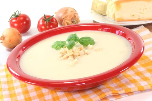 Cheese cream soup with tomato, Croutons and basil on a white background