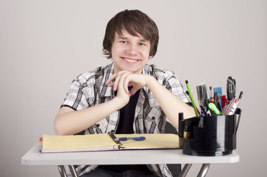 student in exams, sits at the table and reading a book