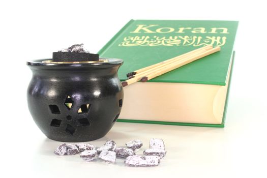 frankincense with incense censer and Koran on a white background