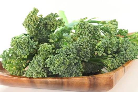 one bunch green Spargoli in a wooden bowl on a white background