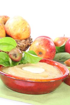 Apple sauce with vanilla sauce and fresh apple with leaves on a white background