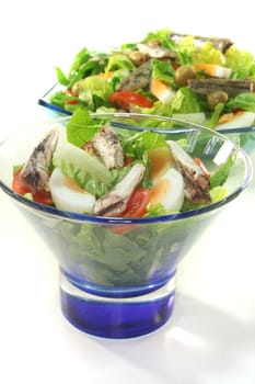 Chef salad with anchovies, egg, tomatoes, olives and salad leaves