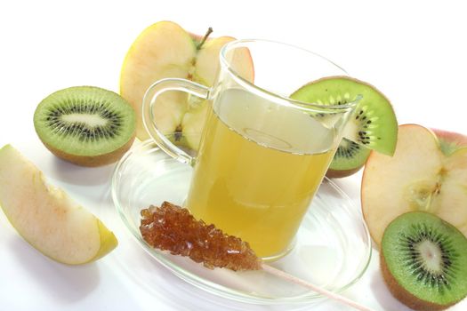 a glass of Kiwi and apple tea with fresh kiwis and apples