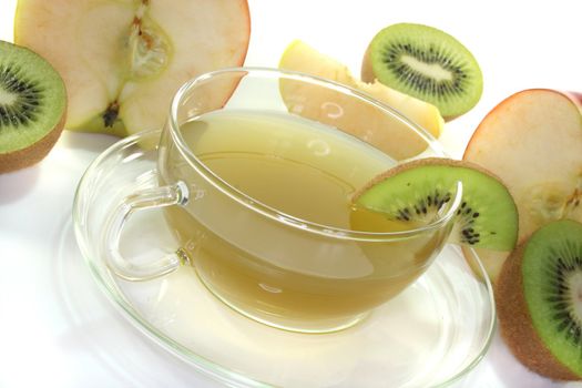 a glass of Kiwi and apple tea with fresh kiwis and apples