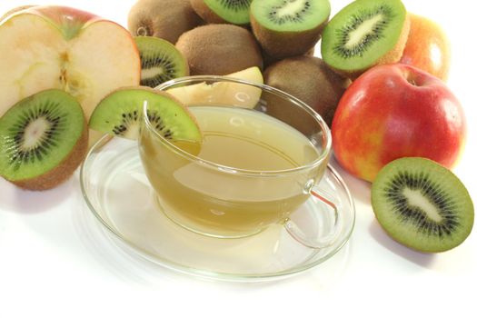 a glass of Kiwi and apple tea with fresh kiwis and apples