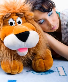 Beautiful sleeping girl with her Plush lion
