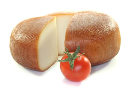 a loaf of smoked goat cheese with tomato on a white background