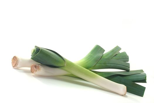 three fresh leeks on a white background