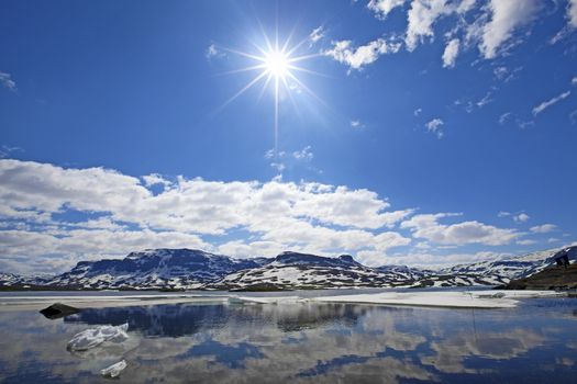 Snowcapped mountains reflecting in the water at Haukeli, Norway